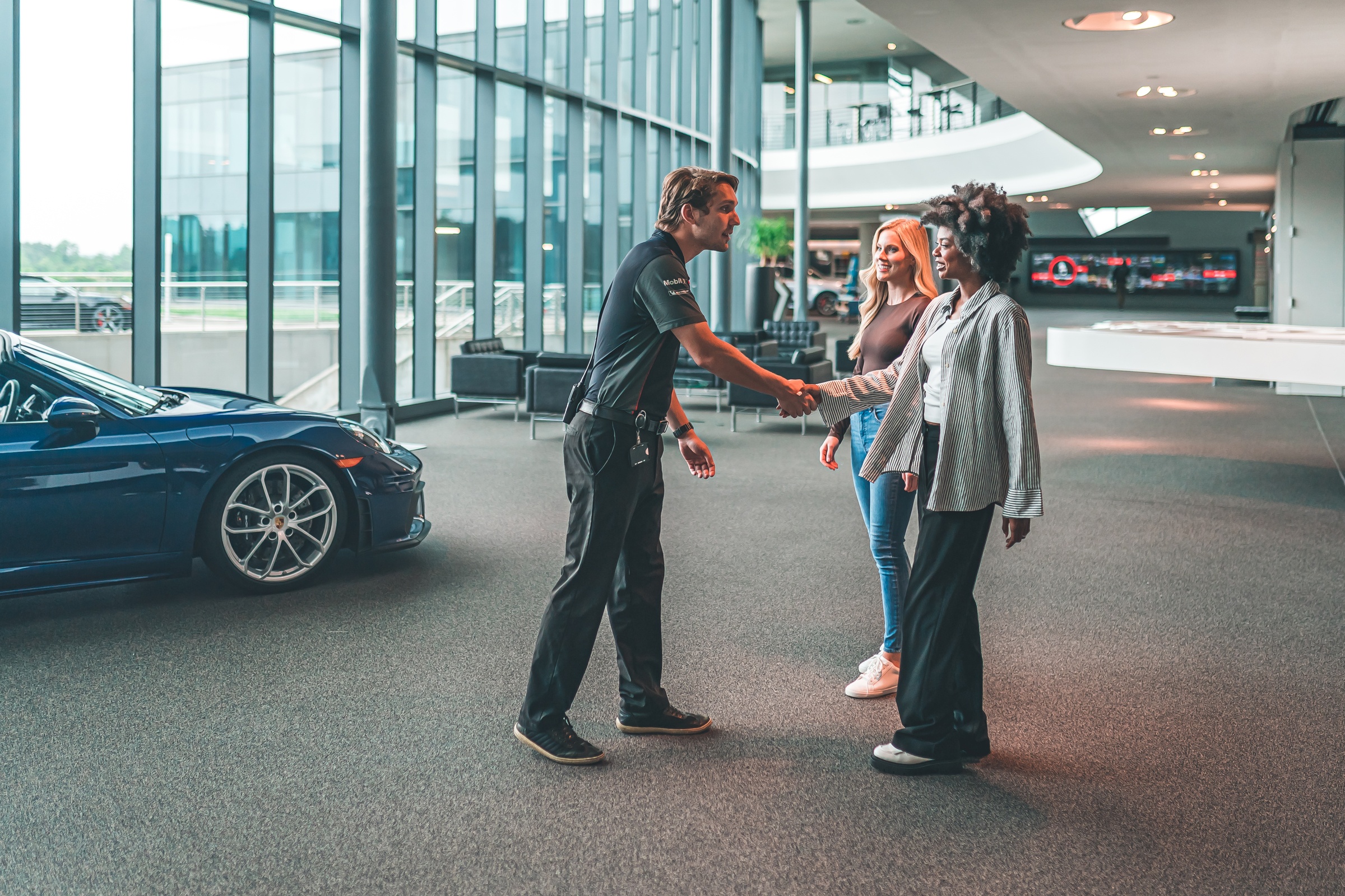 Porsche Experience Center Atlanta employee greeting two guests